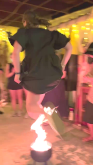 Person in mid-leap over cauldron fire